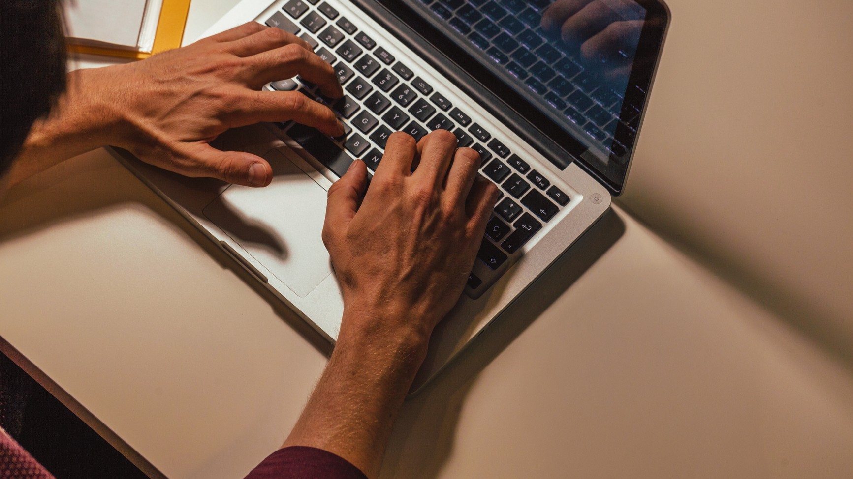 Person tippt am Laptop.