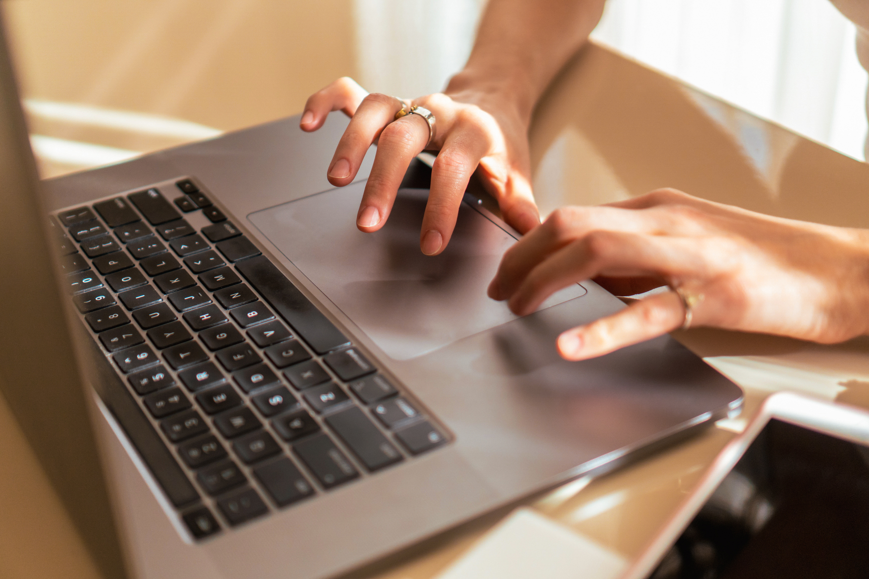 Hands typing on a laptop keyboard.