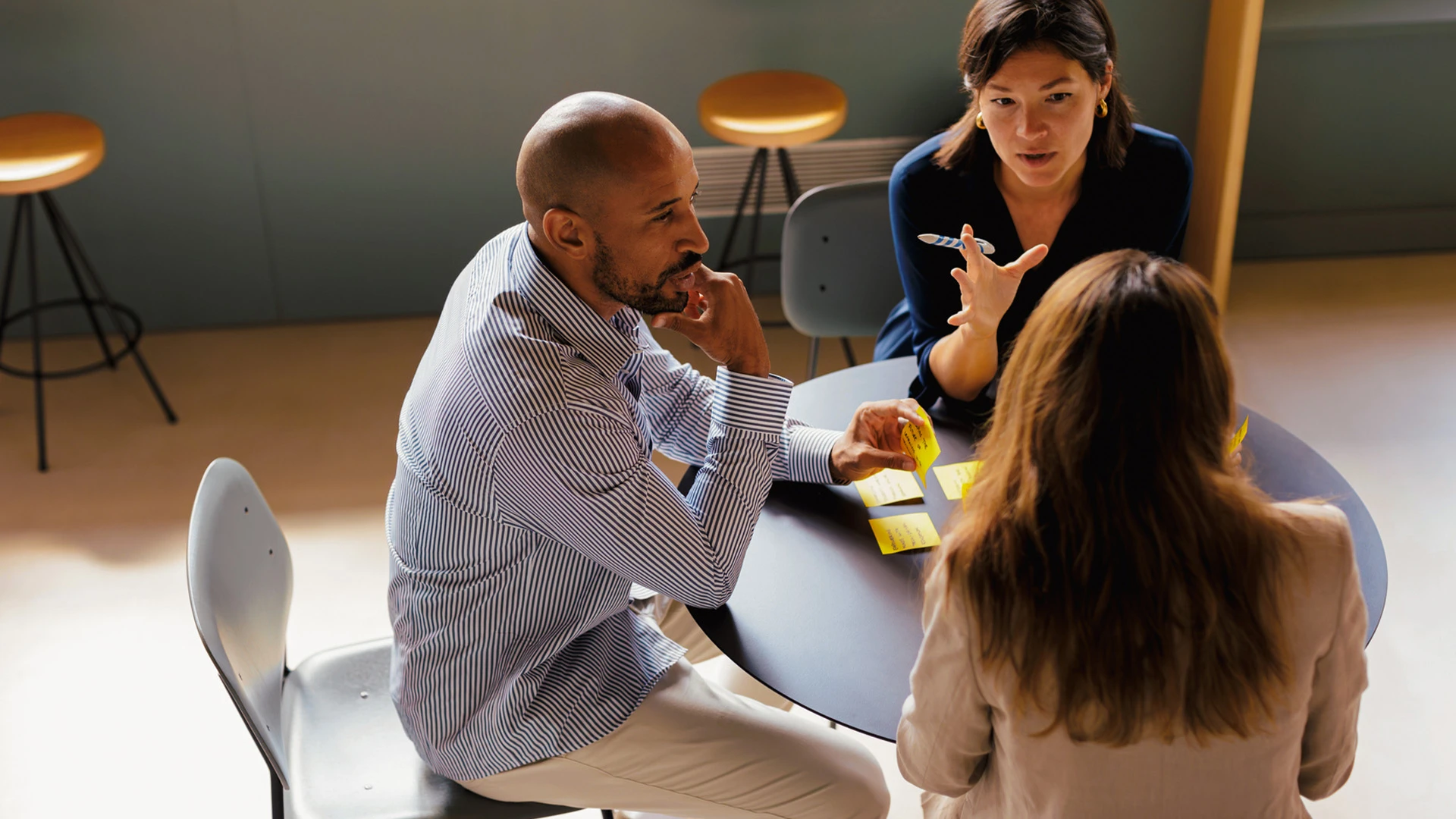 Drei Menschen in Diskussion in Arbeitsumfeld