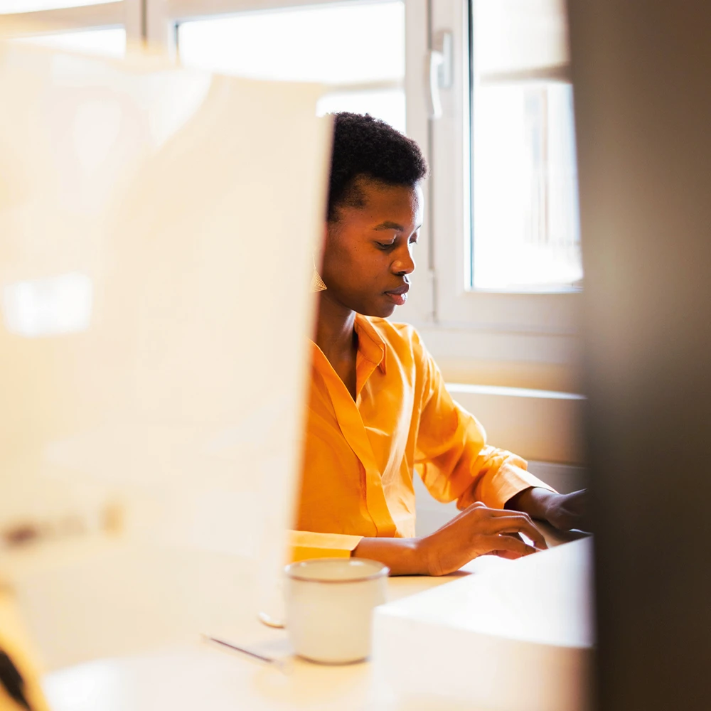 CloseUp einer Studierenden zwischen zwei Bildschirmen