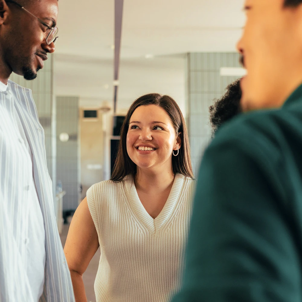 Junge Frau im Gespräch mit zwei älteren Kollegen