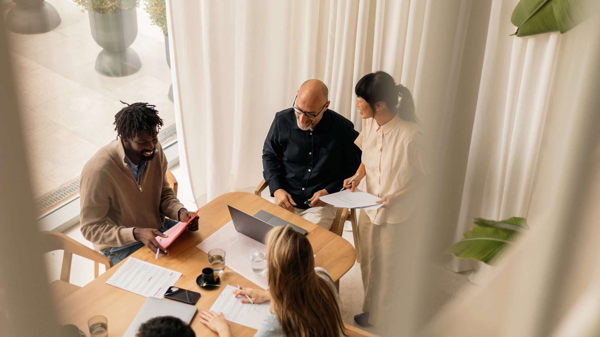 Gruppe von Mitarbeitenden bei der Arbeit aus der Vogelperspektive