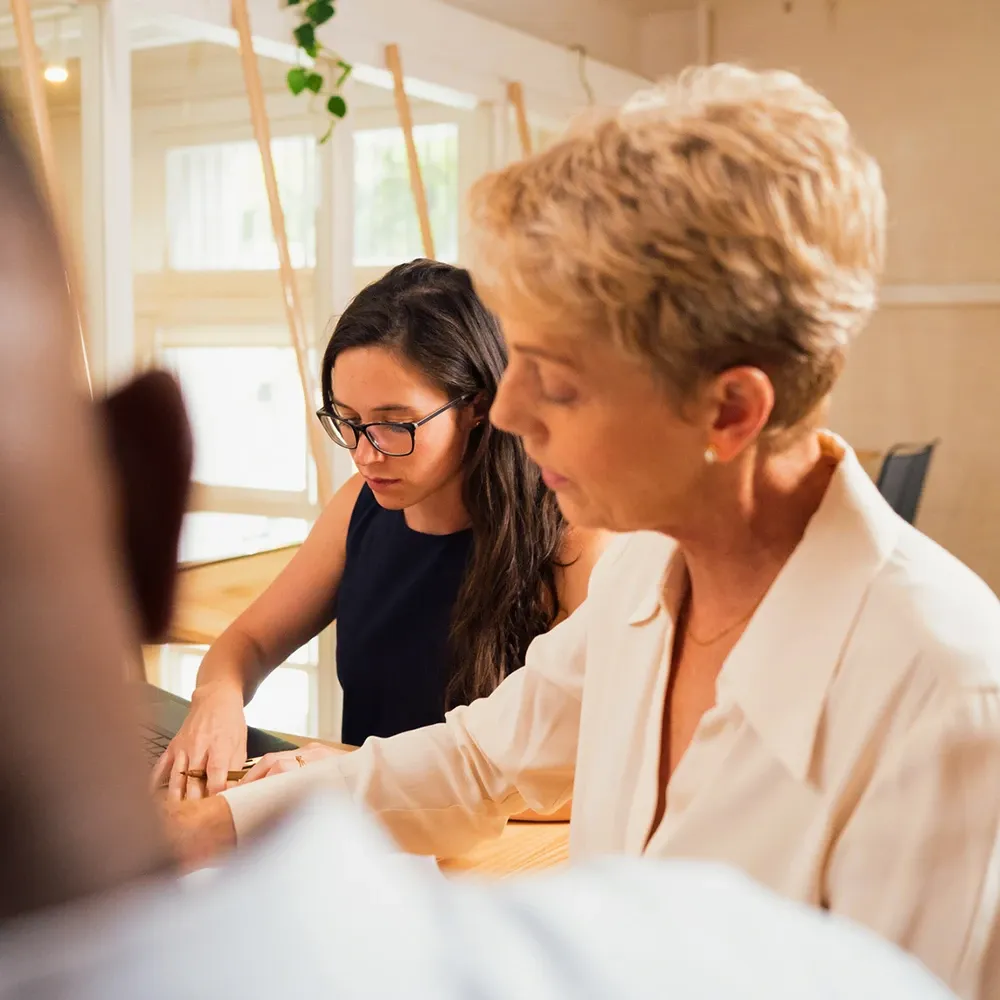 Junge Frau in Arbeitssituation neben ihrer Mentorin