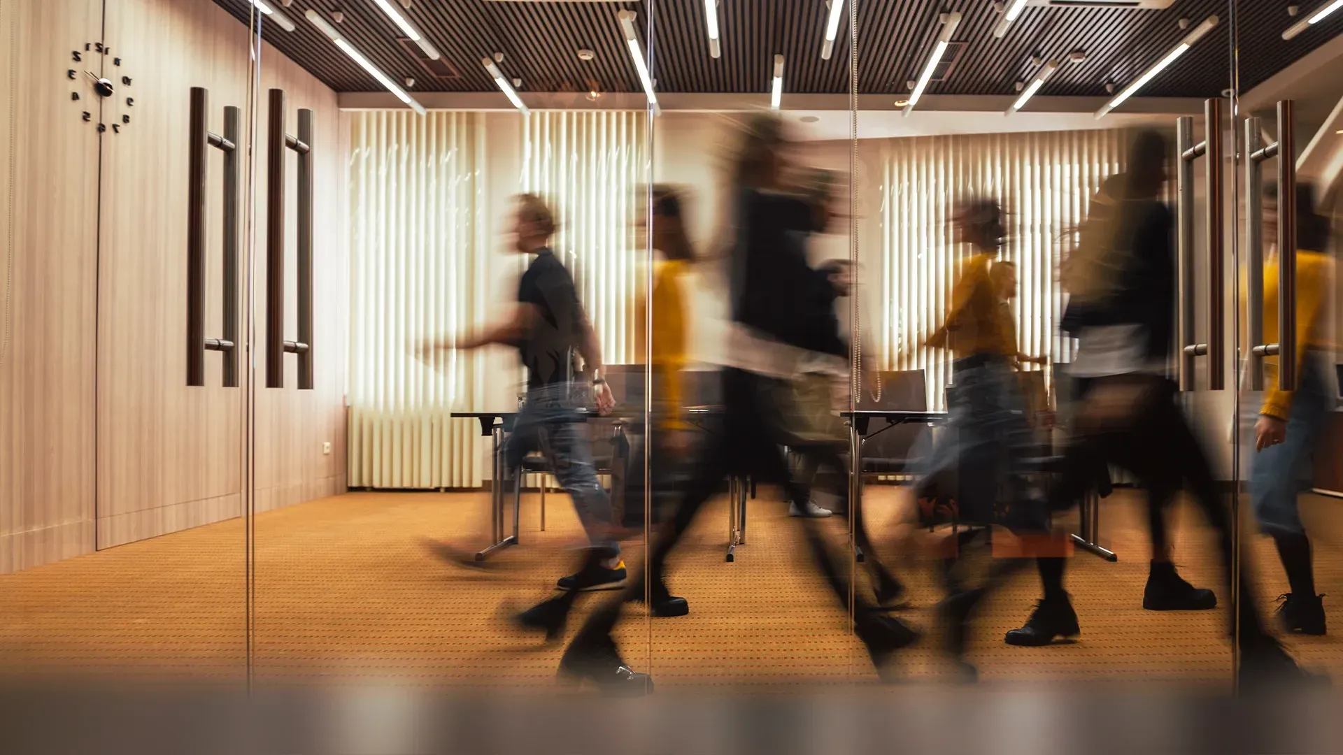 Menschen in Bewegungsunschärfe, die sich vor einem Konferenzraum bewegen