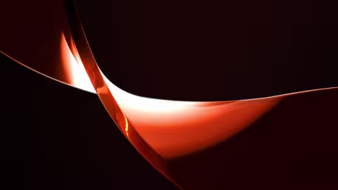 Nahaufnahme eines Ausschnitts einer orangenen Tilde auf schwarzem Hintergrund